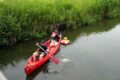 Foto: Kanu mit zwei Personen und großer PlastikEnte im Rettungsring
